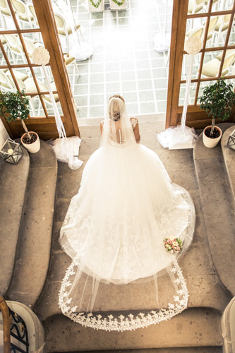 Hochzeitsfotograf Dresden - Eine Braut im Treppenhaus vom Weingut Proschwitz mit beeindruckendem Schleier.