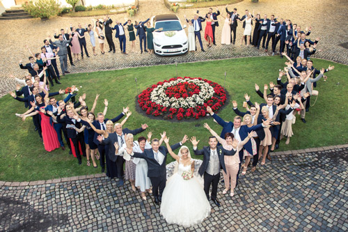 Hochzeitsfotograf Dresden - Eine glückliche Hochzeitsgesellschaft in Herzform von oben fotografiert.